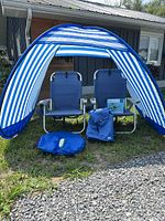 Full view of canopy, two chairs, float package on chair, Bud Light cooler backpack and round canopy bag in foreground