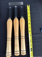 Three carbide-tipped chisels beside tape measure showing 12 in length