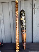 Full view of rain stick and carved mask