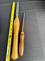 Full view of both tools with tape measure for scale