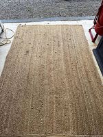 Full view of rectangular jute rug on concrete