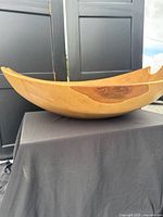 Side view of carved wooden bowl on stand