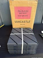Stack of bundled tiles in front of original Vancastle carton