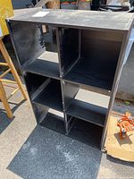Front and side view of the dark wood bookshelf showing six cubbies and wear on surface.