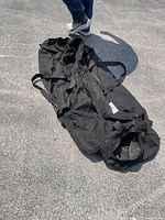 Photo showing the black canvas duffel bag laid out on the ground displaying its large size.