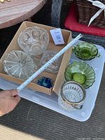 Overview shot showing five bowls and one small bucket arranged on a plastic bin lid, with a measuring tape for size reference.