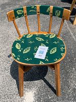 Front view of the wooden kids chair with leaf patterned green fabric seat cushion