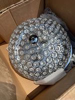 Image showing top view of the round light fixture with clear glass beads and central chrome piece