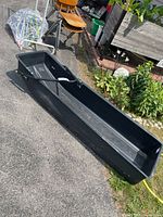 Side profile of plastic tub and attached metal tow bar