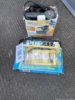 Photo showing ActivePower air compressor in box with power cord and gauge, and Emhart POP 2000 staple gun in original packaging.