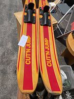 Photo showing the front section of the two wooden water skis with 'CUT N JUMP' text and bindings.
