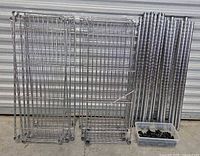 Photo showing multiple wire shelves stacked and arranged on ground with metal posts and black sleeves in foreground