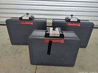 Three gray rectangular First Alert fireproof lock boxes seen from the back side showing the body and locking latches.