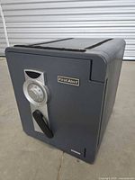 Front view of the closed First Alert safe showing the combination dial and handle locking mechanism.