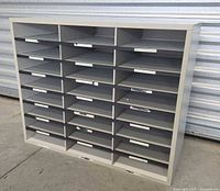 Front view of gray wood mail sorter showcasing 24 compartments.