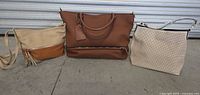 Photo showing all three handbags side by side: a large brown tote, a beige/brown crossbody with tassels, and a cream perforated bag.