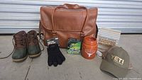 Full grouping of the lot on concrete with cooler bag, boots, gloves, Scentsy warmer, and fishing line, plus Yeti cap and ceramic warmer