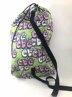 Side view of bag showing graphics, shape and strap