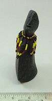 Front view of basalt figure showing form and bead necklace