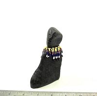 Front view of basalt carving with beaded collar and ruler for scale