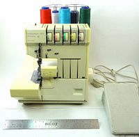 Front view of Pfaff Hobbylock 797 serger with foot control and ruler for scale