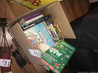 Top view of box showing several books including 'Pushing 40' and 'Mad' comic book style cover visible on top