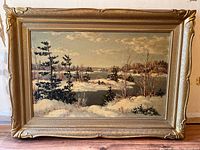 Full front view of the framed winter landscape painting showing the gold ornate frame.