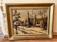 Framed winter landscape painting with snow-covered trees, cabin, and fence, signed by V. Kuusisto in the lower left.