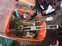 Orange basket with levels, hand power drill, electric drill with power cord, and Mastercraft wrenches.