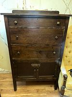 Front view of vintage wooden dresser showing three drawers and cabinet doors below.