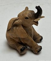 Front view of the vintage baby elephant figurine showing trunk lifted and facial features.