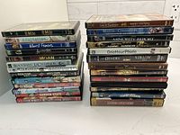 Two stacks of preowned DVD and Blu-ray movie cases displaying spines and artwork for identification