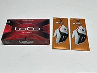 Photo showing boxed Dunlop Loco Distance golf balls and two Bridgestone golf gloves in packaging.