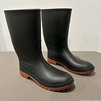 Pair of men's black rubber boots shown side by side on a neutral surface to display shape and condition.