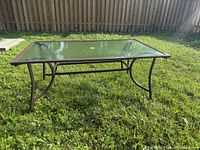 Full view of rectangular glass patio table on grass