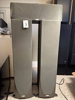 Front view of two Esprit v.4 tower speakers with centre channel on top, grille covers installed