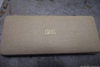 Closed cream textured hard rectangular case with gold embossed 'CROSS' on the top.