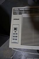 Close-up of the control panel on the front left top side showing digital display and buttons for temperature control, fan speed, mode, and power.