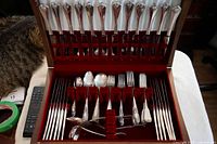 Full view of the wooden box cutlery set showing 24 knives, forks, spoons and serving pieces organized inside.