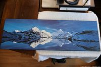 Photo of the entire rectangular wall art picture showing snow-covered mountains reflected in a lake.