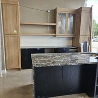 Front view of two-tone bar area display showing black base cabinets and quartz island