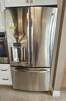 Exterior front view of stainless steel French door refrigerator showing water and ice dispenser and digital control panel