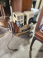 Full view of Craftsman air compressor showing tank, motor housing, handle, wheels and coiled hose