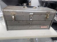 Front view of gray Craftsman toolbox showing exterior condition and locking latches
