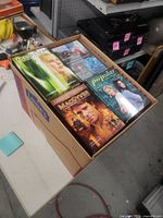 Open box showing several DVD sets including Medium, MacGyver and Popular