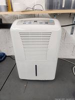 Front view of white GE dehumidifier showing grille and overall condition