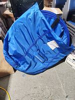 Blue folded JUGS Instant Screen in carry bag lying on floor