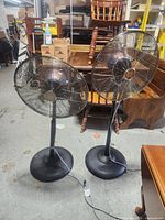 Front view of two pedestal fans showing missing blades and overall design