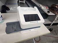 Three-quarter front view showing overall machine and feed tray