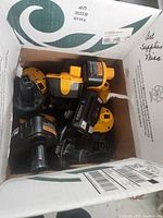 Open box containing assorted Dewalt, Ryobi, Craftsman and Sunjoe cordless power tool battery packs